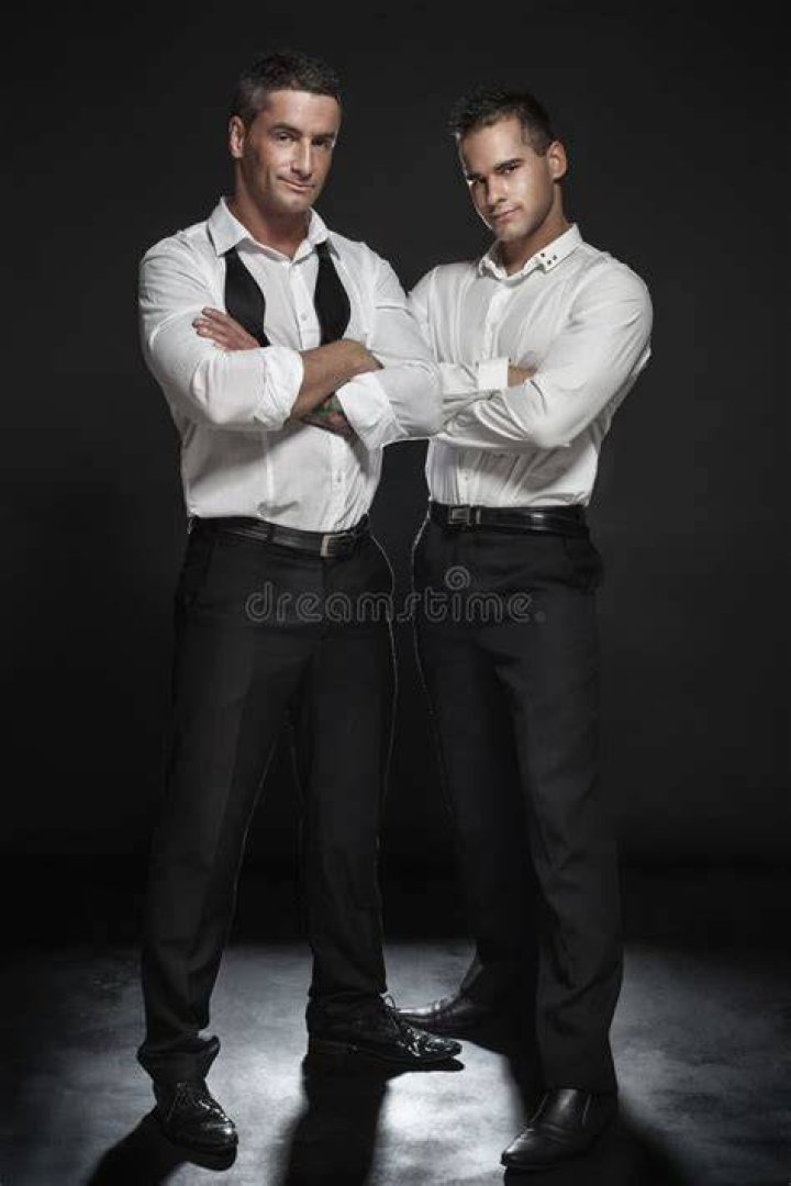 the two men are posing for pictures with their hands up and one is